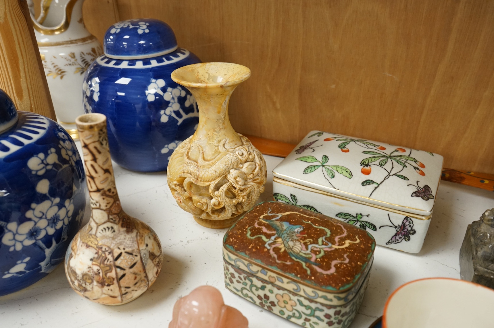A group of mixed Chinese and Japanese ceramics to include soapstone carvings, prunus flower ginger jars, rose quartz Buddha and pair of famille rose bowls. Condition - varies, mostly fair/good